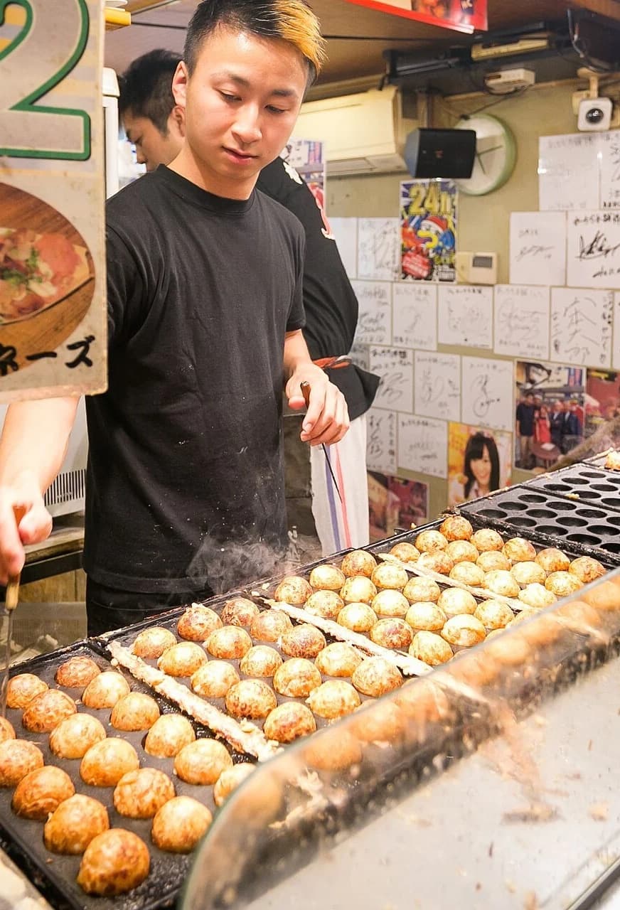 Cook preparing takoyaki at an Osaka stall