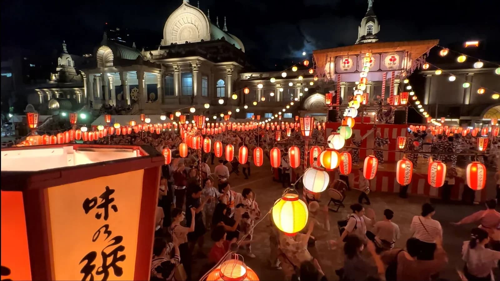 El bon odori del templo Tsukiji Hongan-ji de noche, con farolillos rojos y gente bailando