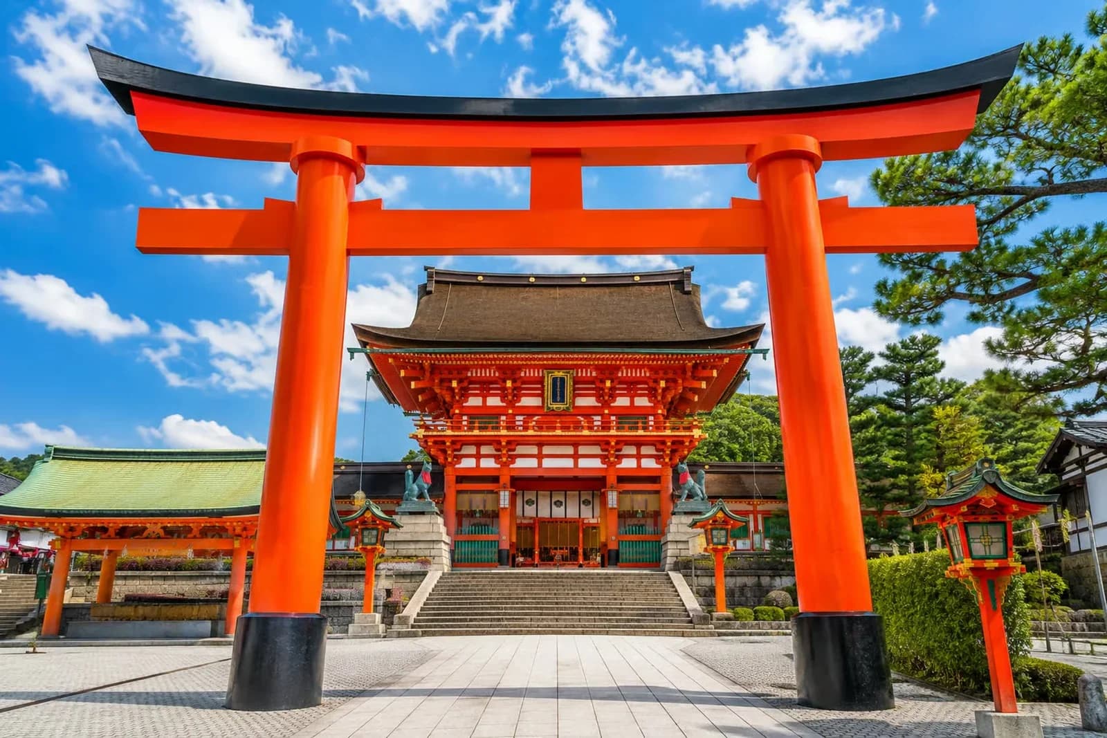 El gran torii de la entrada de Fushimi Inari, con la puerta Romon y el santuario principal detrás