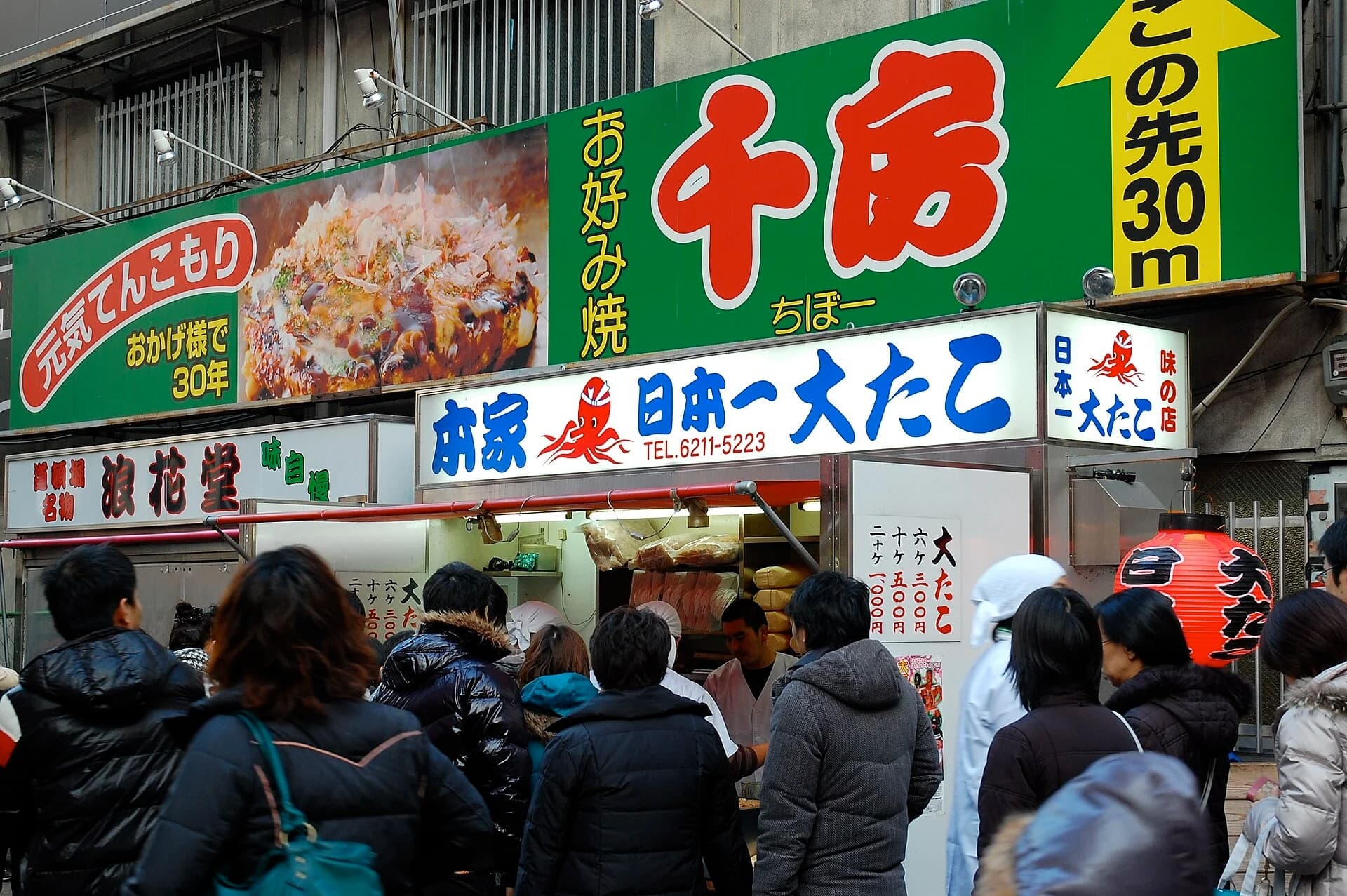 Personas haciendo cola ante un puesto tradicional de takoyaki en Dotonbori, Osaka