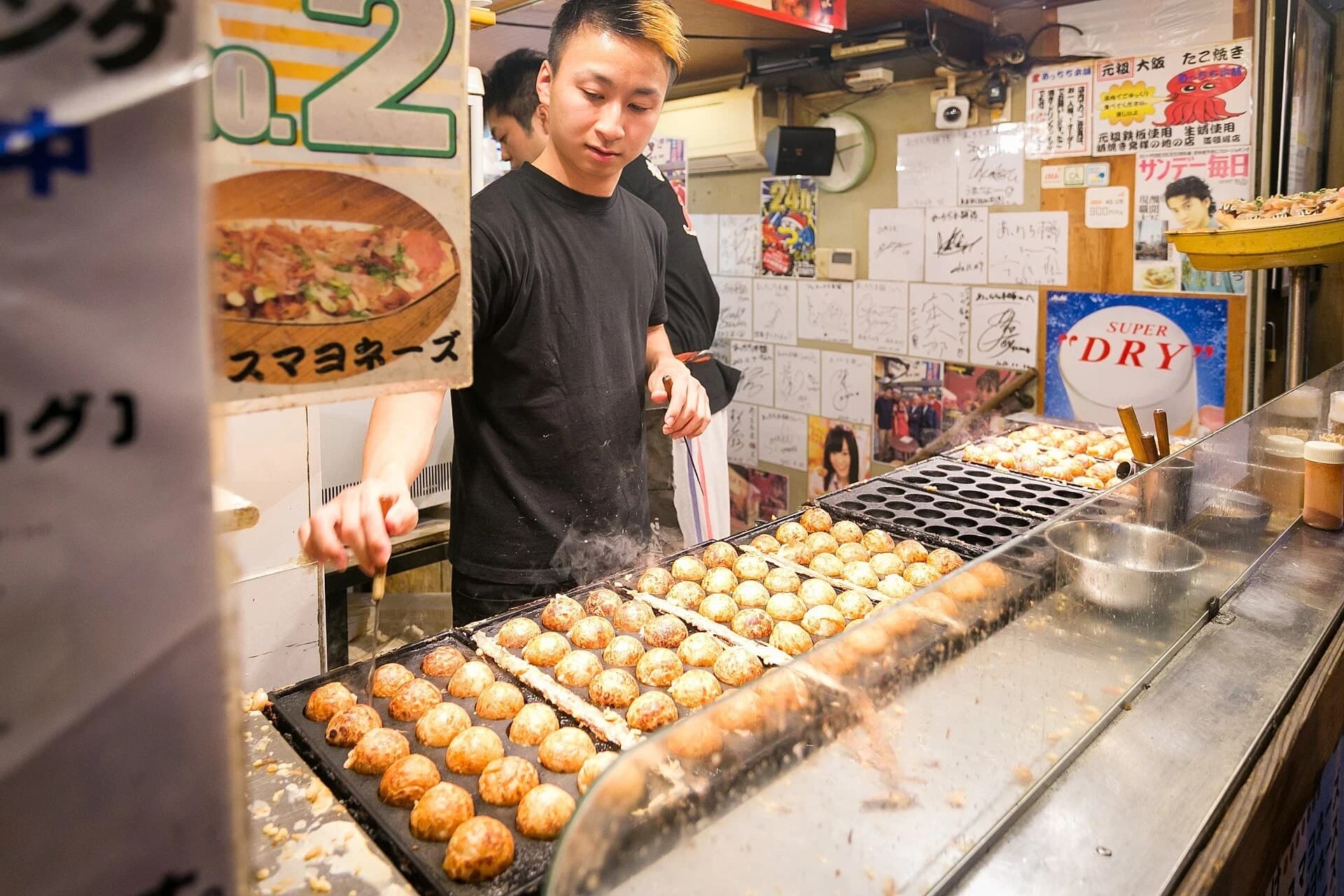Cook preparing takoyaki at an Osaka stall