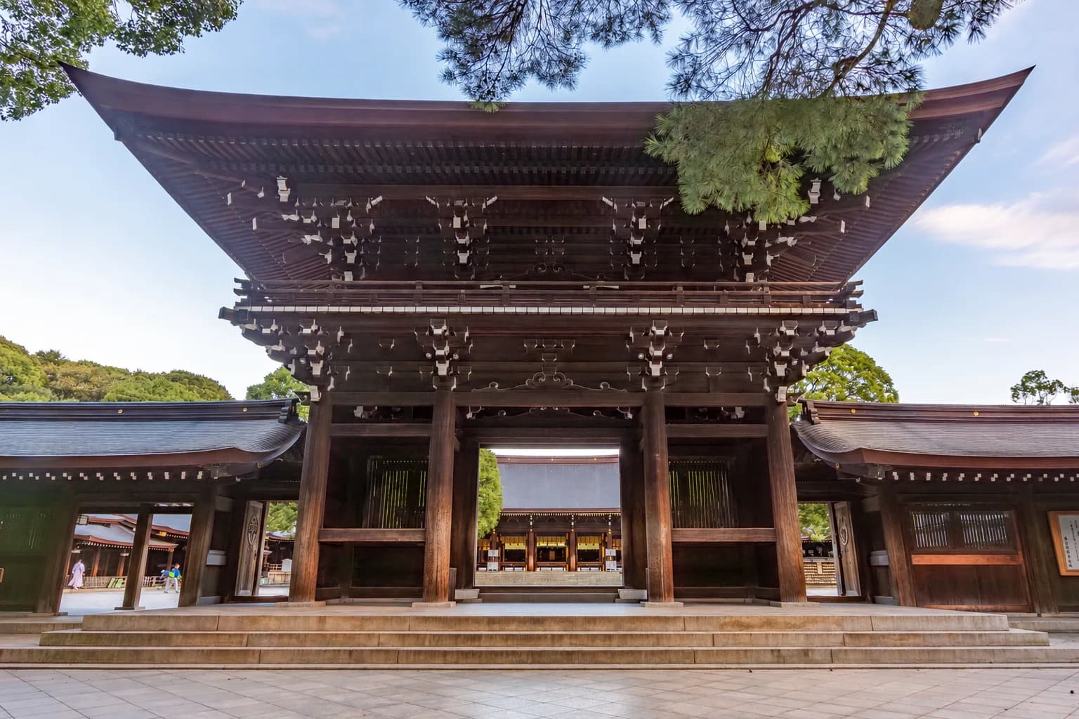 La puerta principal de madera del santuario Meiji entre los árboles