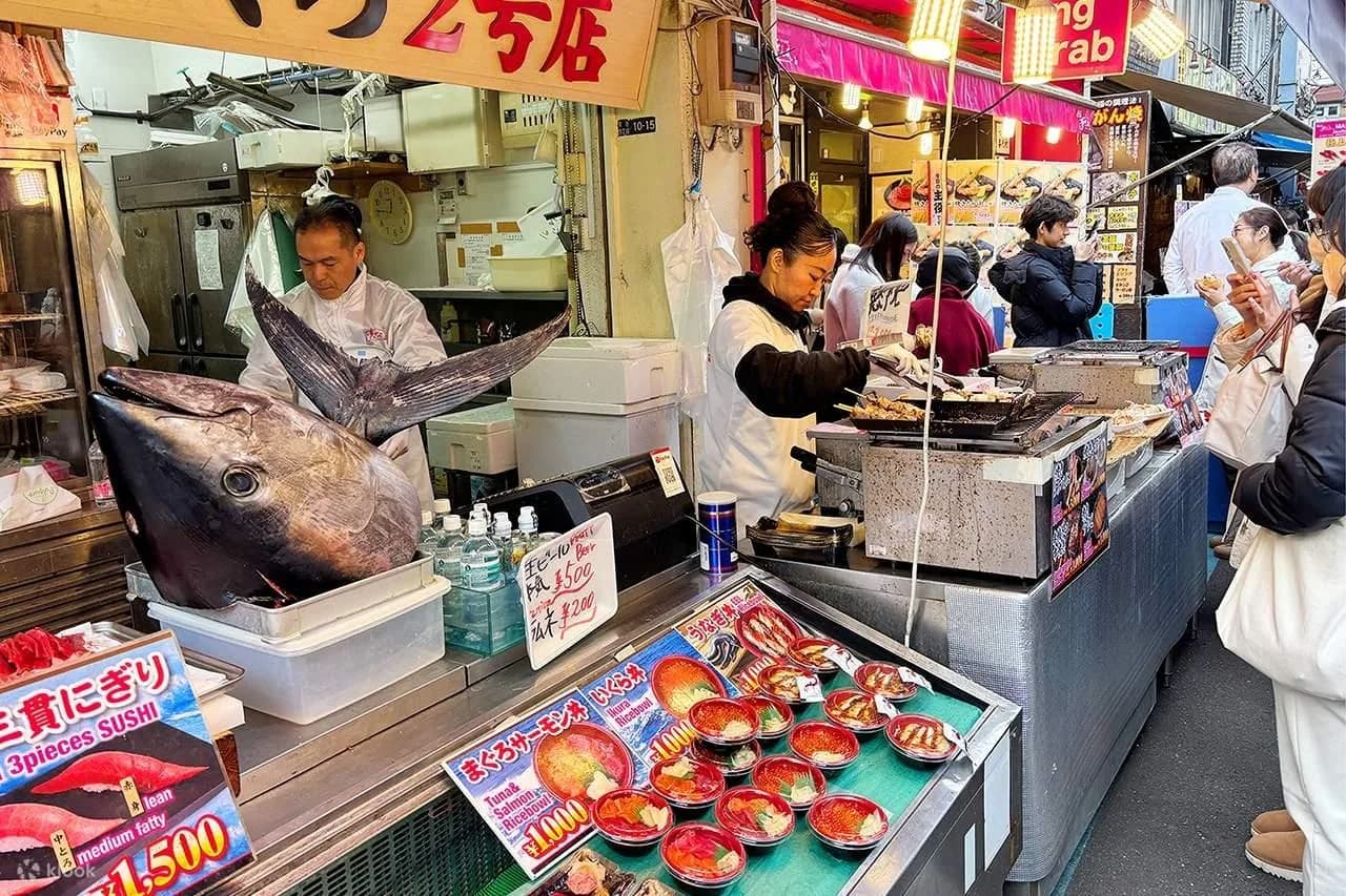 Bandejas de sashimi y marisco fresco en un puesto del mercado de Tsukiji