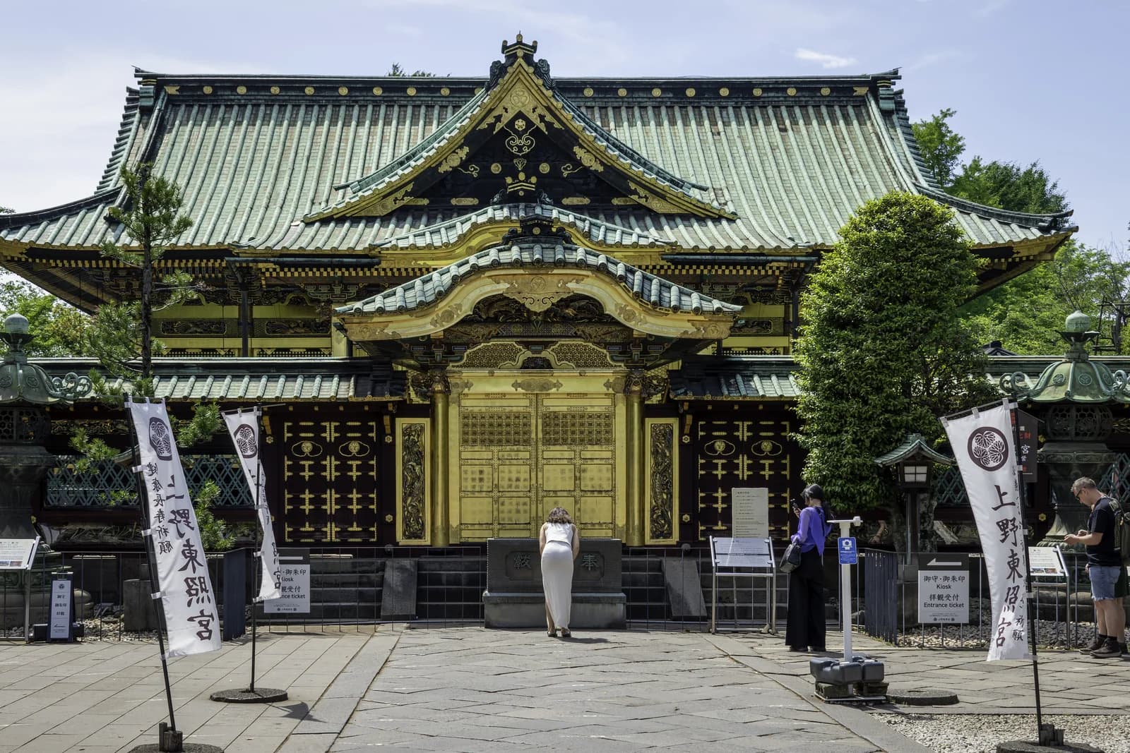 La fachada dorada del santuario Ueno Toshogu entre los árboles del parque