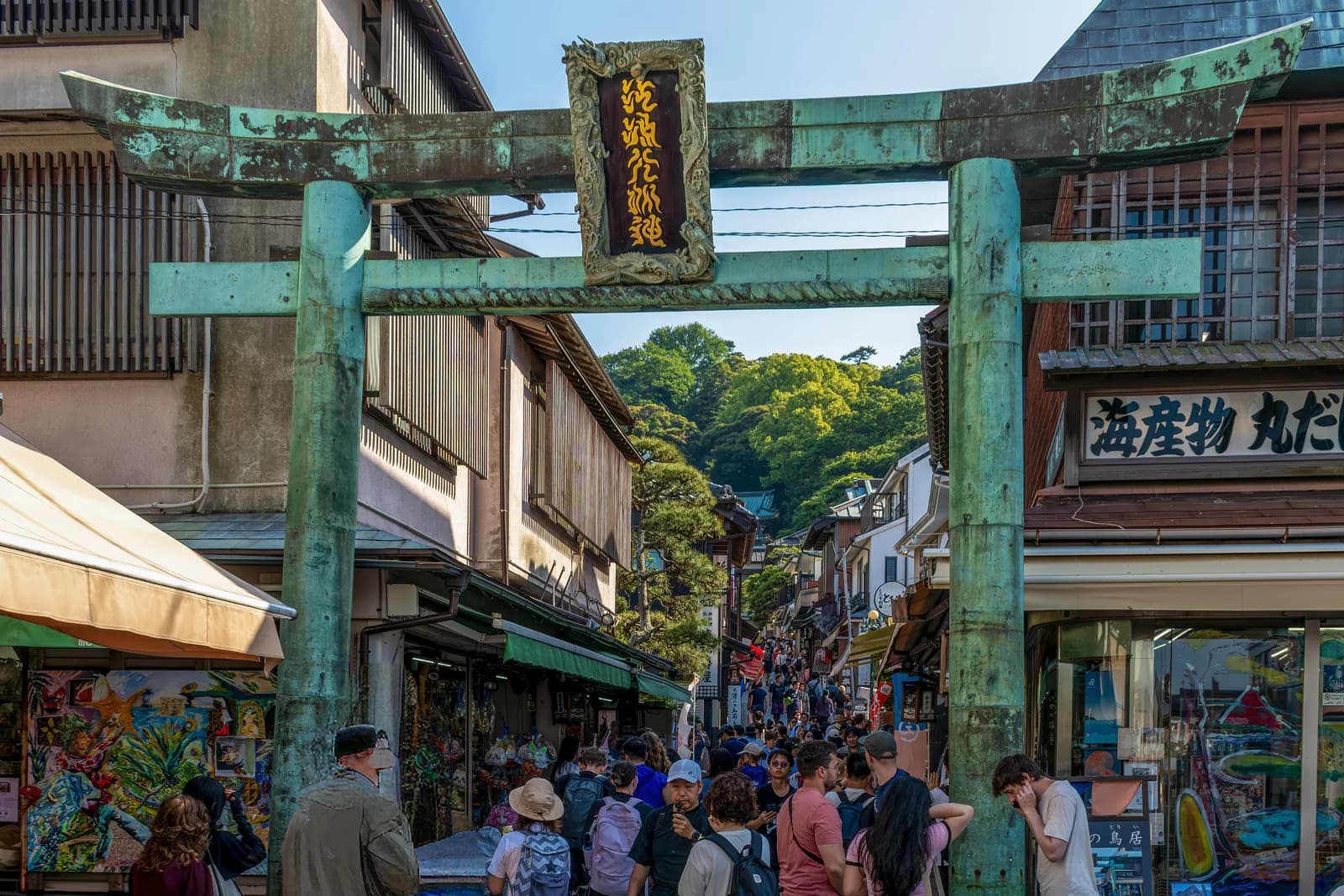 El torii de bronce de Enoshima, con la calle de tiendas Benzaiten Nakamise subiendo detrás