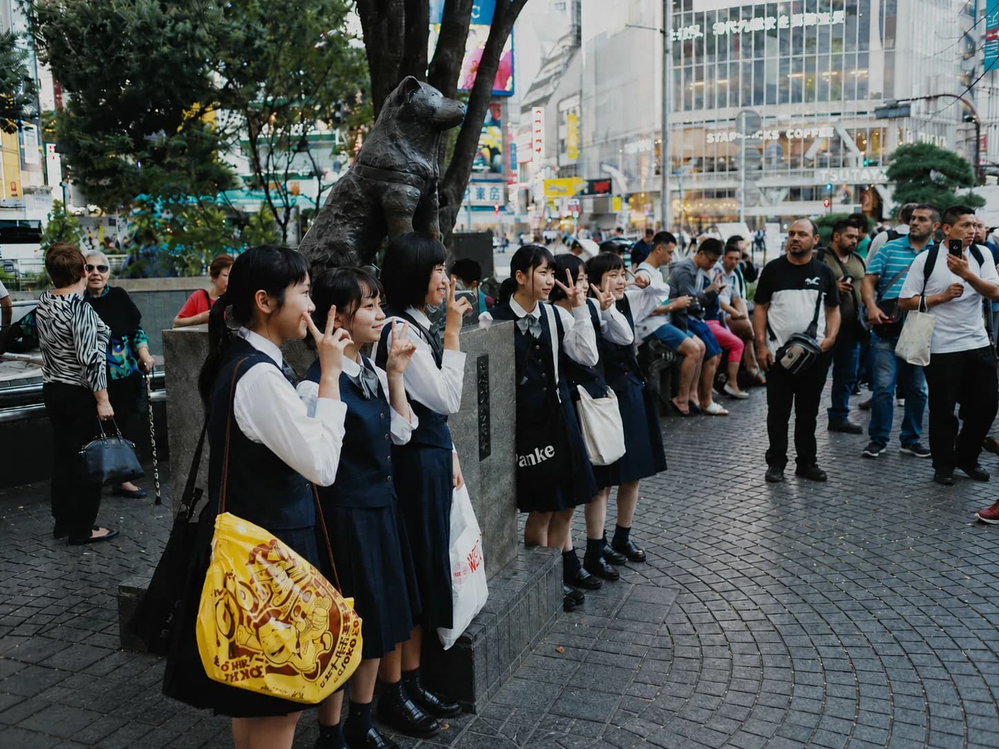 Colegialas y turistas haciendo fotos a la estatua de Hachiko
